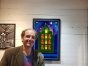 Artist Eddie Hall standing beside his reclaimed-material artwork exhibiting at Klekolo World Coffee